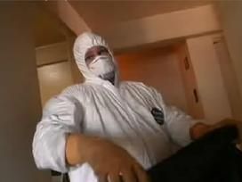 A person dressed in a white hazmat suit and mask.