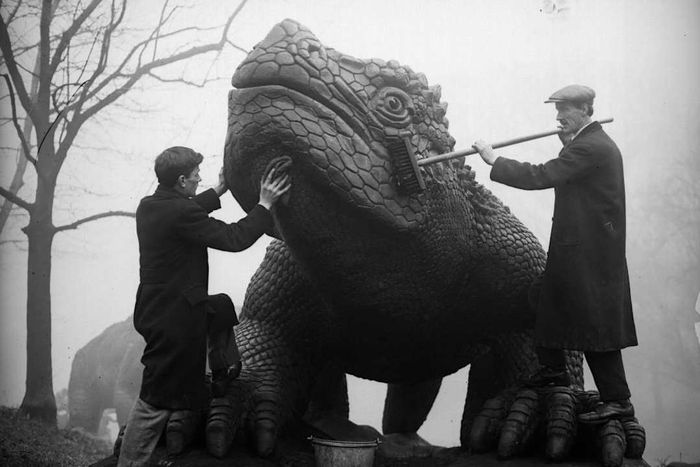 Two workers apply finishing touches to a dinosaur model by Benjamin Waterhouse Hawkins.