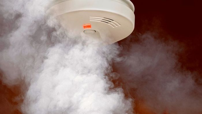 Smoke Detector Installed on Ceiling with Smoke Below