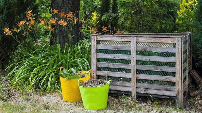 A homemade compost bin constructed from wooden planks.