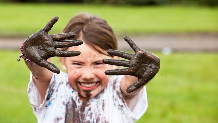 A girl having fun playing in the mud