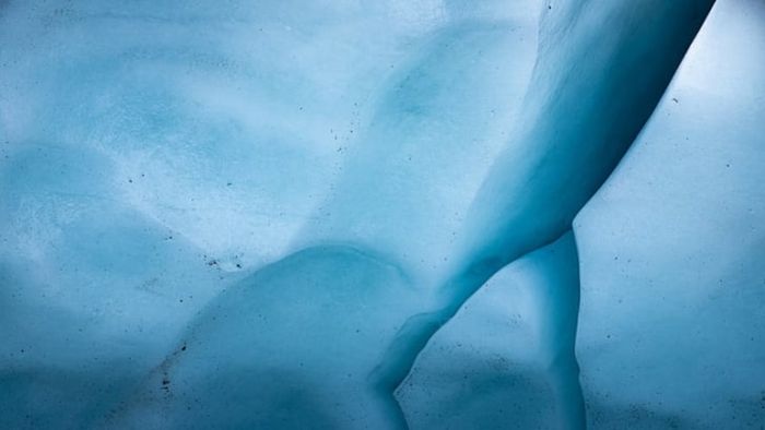 The dense ice of the glacier reflects blue light in Glacier National Park.