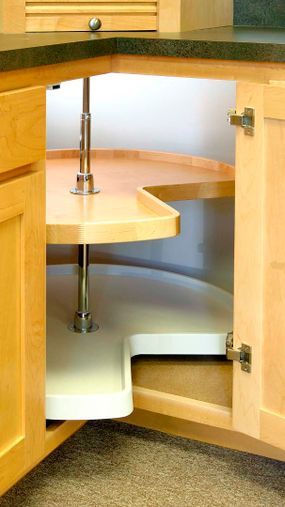A rotating shelf (known as a Lazy Susan) inside a kitchen corner cabinet.