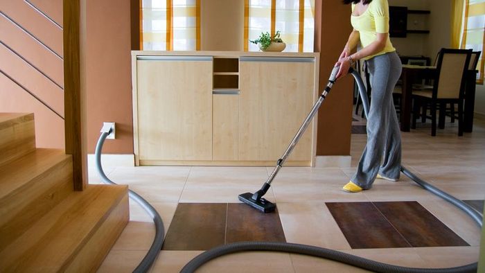 A woman using a central vacuum system to clean her home