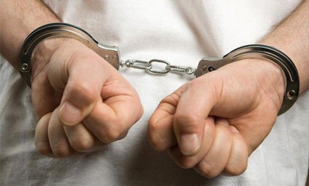 A criminal wearing handcuffs