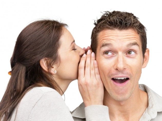 Young woman telling a secret to a man