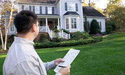Man holding a document outside a house