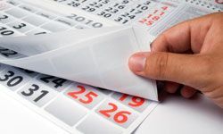 Hand turning through pages of a calendar