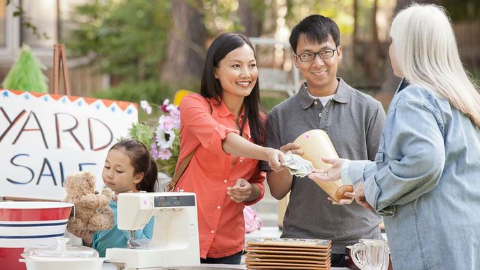 A family making a purchase at a yard sale.