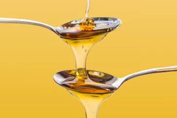 A still life mimicking the popular chocolate fountains found at children's parties, where the rich flow of food cascading from spoon to spoon emphasizes its nutritious quality.