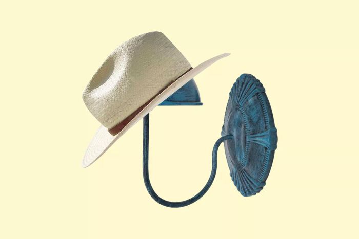 A hat displayed on a green Owlgift Hanger Display Rack set against a bright yellow backdrop