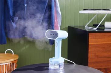 The Proctor Silex Compact 2-in-1 Garment Steamer/Iron resting on a table