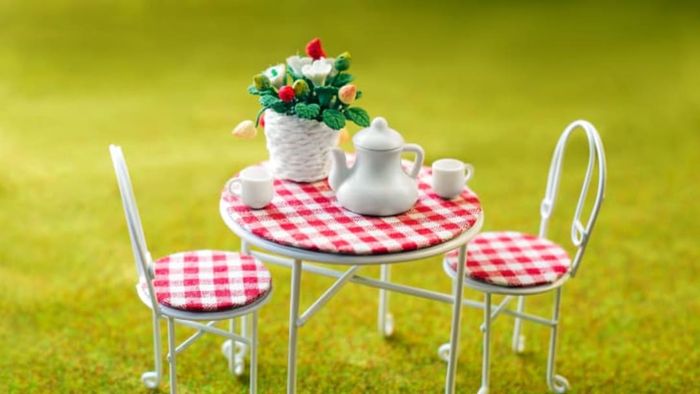 miniature garden furniture with tea set and flowers