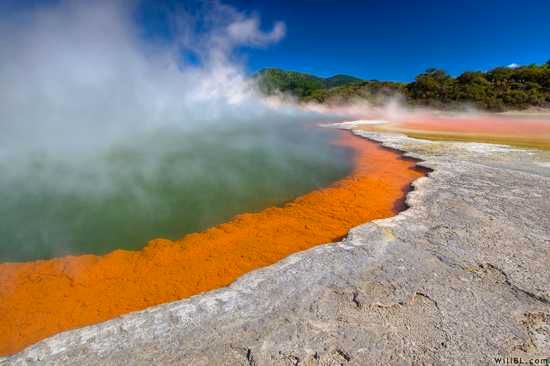 Champagne Pool, a magnificent geothermal hot spring situated in New Zealand's Wai-O-Tapu geothermal region, is named for the constant bubbling of carbon dioxide, resembling the effervescence of champagne. Created by a hydrothermal eruption around 900 years ago, the pool is relatively young on a geological scale. Its crater has a diameter of 65 meters (213 feet) and a depth of about 62 meters (203 feet). The pool contains an impressive 50,000 cubic meters of geothermal fluid, and the orange color around its edges is a result of arsenic deposits.