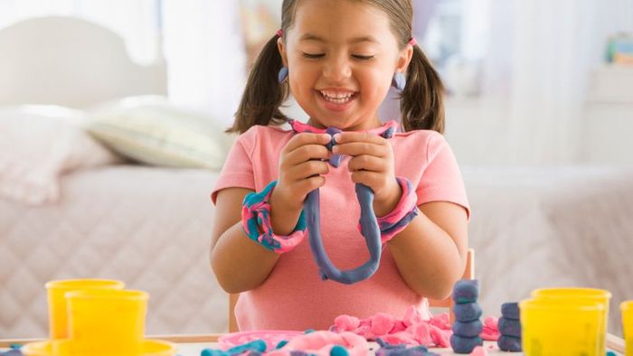 A child molding play dough.