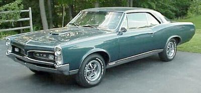The 1967 Pontiac GTO, frequently called the first true muscle car, is easily identified by its famous split-grill front design. First introduced as an option on the 1963 Pontiac LeMans, the GTO became its own separate model in 1966. The 1967 model marked the end of the first-generation look, complete with stacked headlights. Inside, the GTO came with bucket seats, a walnut-grain dash, dual exhaust, and a heavy-duty suspension system. Under the hood, the 1967 model featured an upgraded 400 cid engine, replacing the 389, and transitioned from a tri-power carb setup to a single 4bbl carburetor. The top performance engine, the 400 HO, was rated at 360 hp at 5,100 rpm, and adding Ram Air increased peak rpm. These GTOs could typically run the quarter-mile in the low 14-second range. Almost 82,000 GTOs were sold in 1967, with 13,872 of those equipped with the 400 HO engine, and only 751 featuring the Ram Air option.