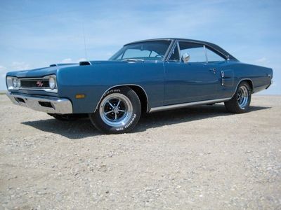 The 1969 Dodge Coronet R/T was part of a legendary muscle car duo, with the Coronet Super Bee being its close relative. While both models shared similar performance, each had distinct qualities. The R/T, available from 1967, was the epitome of 'road/track' performance, boasting the powerful 440 Magnum or Hemi engine options, making it a standout in the muscle car world. The Super Bee, Dodge's answer to the Plymouth Roadrunner, was more affordable and lighter, thanks to fewer luxury features. The base Super Bee came with the 383 cid engine, a common choice, with over 24,000 units sold, while the R/T only offered the 440 Magnum or Hemi. These muscle machines could easily race down the quarter-mile in the mid-13-second range. Production figures show that about 6,800 R/Ts were made in 1969, including 400 convertibles, of which only 10 featured the Hemi engine. Of those, only 4 were equipped with the rare 4-speed transmission.