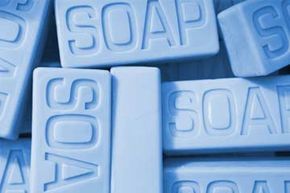 A close-up of blue soap bars with the word 'SOAP' etched on them.