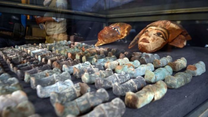 On December 9, 2017, a photograph captured ancient Egyptian wooden funerary masks and small figurines that were found and retrieved from the recently uncovered 'Kampp 150' tomb at the Draa Abul Naga necropolis, located on the west bank of the Nile in Luxor, approximately 400 miles south of Cairo.