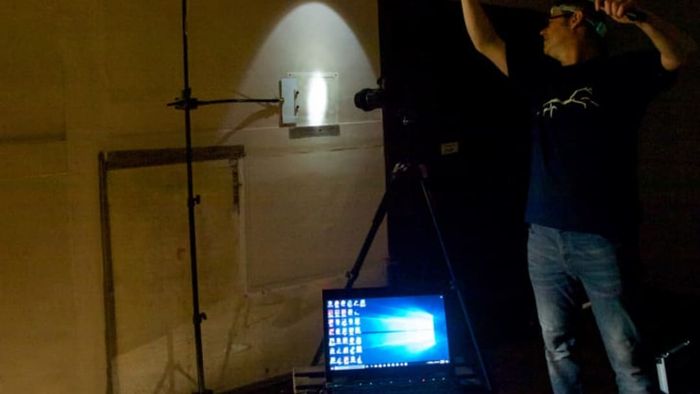A conservator uses light imaging technology to inspect the walls of Woolsthorpe Manor, the childhood home of Sir Isaac Newton.