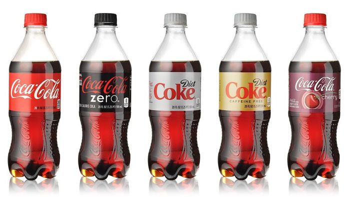 A collection of five Coca-Cola bottles showcasing various flavors
