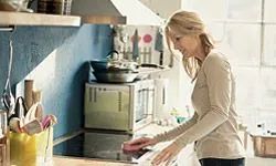 Woman cleaning up the kitchen. 