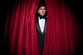 Person peeking from behind the theater curtain
