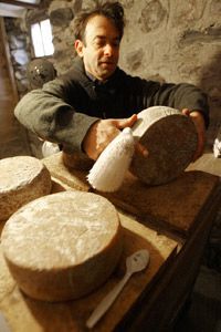 Author Brad Kessler examines his homemade goat cheese in Vermont.