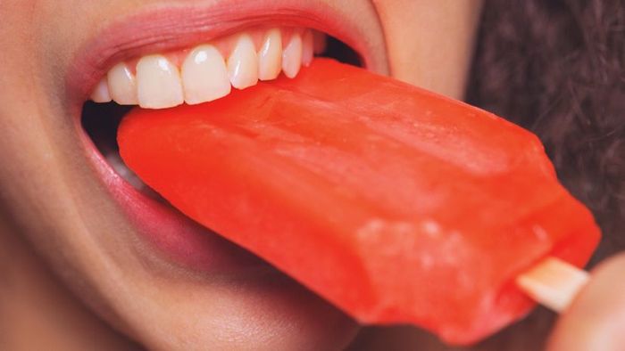A woman enjoying a popsicle.