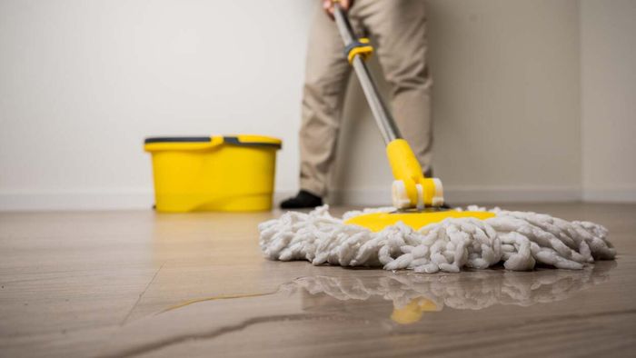 a person cleaning the floor using water