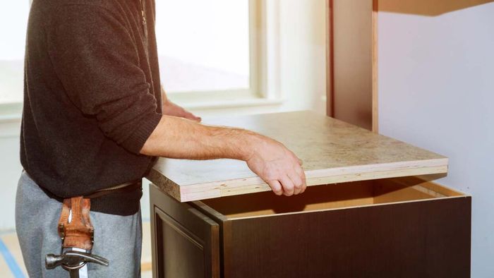 A person skillfully installing a laminate countertop