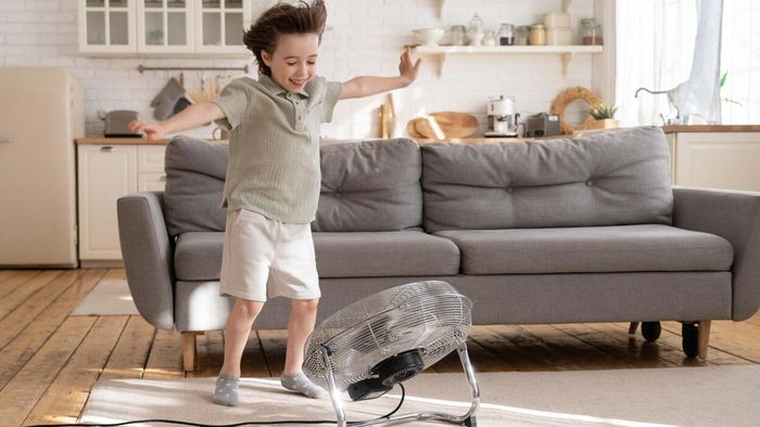 A child enjoying a fan-cooled room.