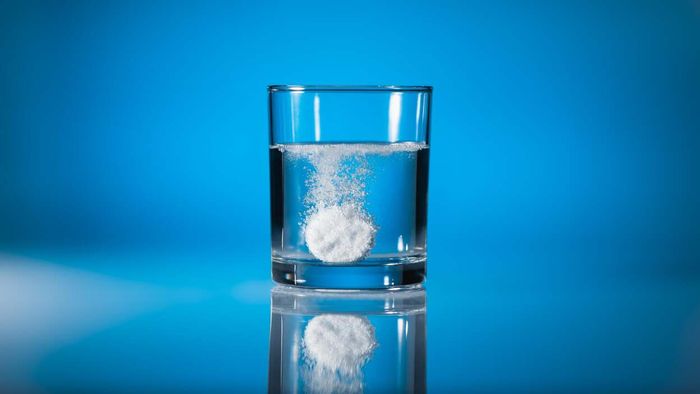 A glass of water with an Alka-Seltzer tablet resting at the bottom.