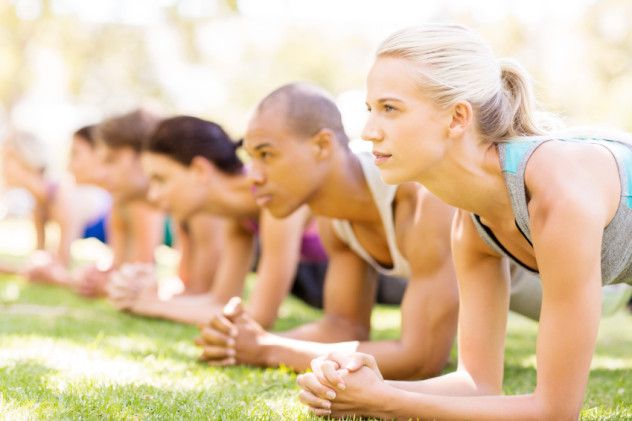Woman With Friends In Plank Position At Park