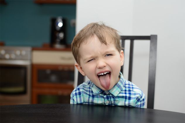 A 4-year-old boy sticks out his tongue