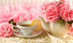 a tea kettle paired with delicate pink floral arrangements