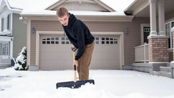 teenage boy clearing snow