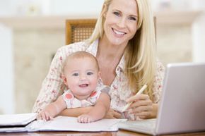A mother and child working together on a computer, engaged in various tasks.