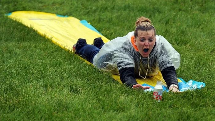 an adult enjoying a ride down a Slip 'N Slide