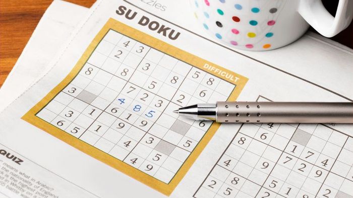 A newspaper spread featuring a Sudoku puzzle.