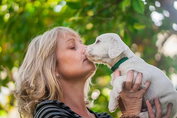 A woman playing with a Dalmatian puppy outdoors