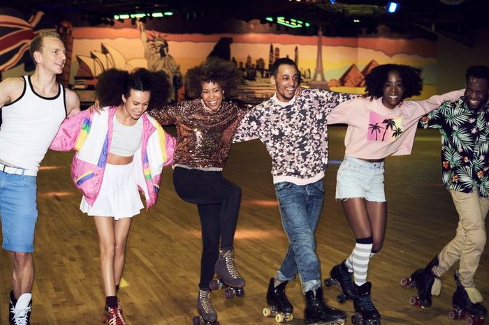 Six individuals skating together on roller skates