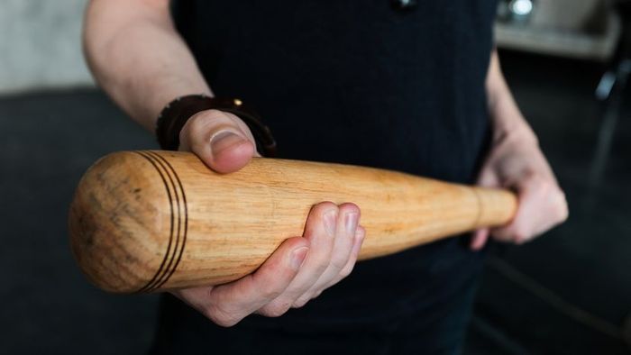 A man gripping a baseball bat.