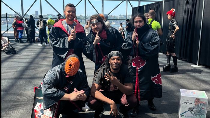 Jordan Calhoun posing with four individuals dressed as Akatsuki villains from the anime 'Naruto'