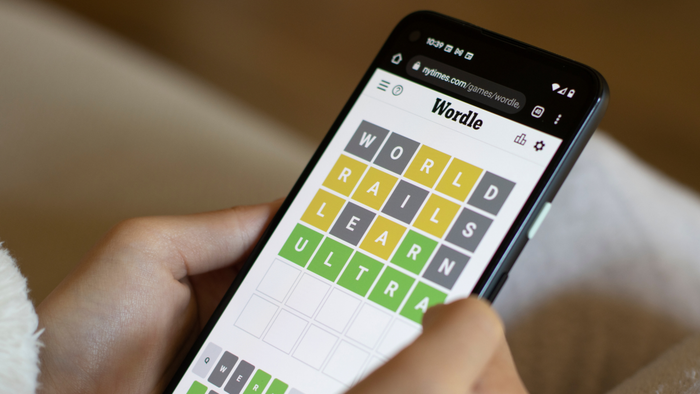 An individual engaging in a game of Wordle on their smartphone