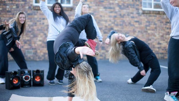 A young female dancer showcasing impressive breakdance moves.