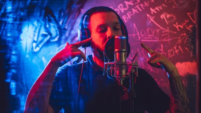 A young artist recording vocals in a music studio.