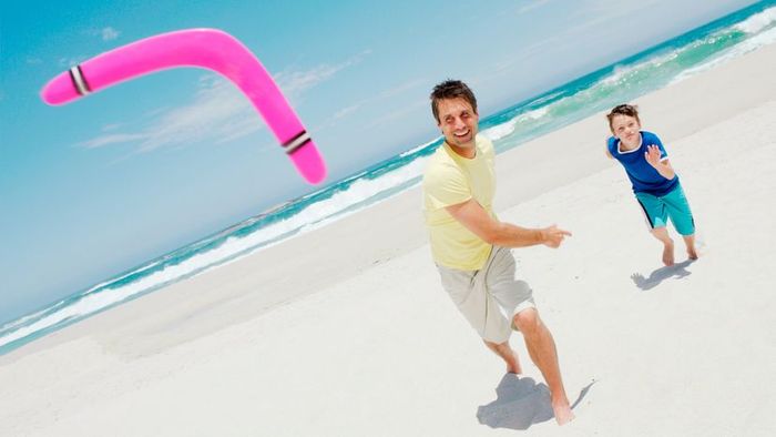 A man skillfully throwing a boomerang on a sunny beach