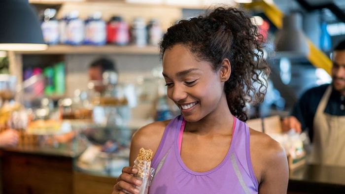 a fitness enthusiast consuming a protein bar
