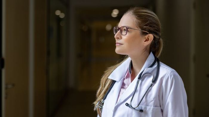 An image depicting a female doctor diligently working in a hospital environment.
